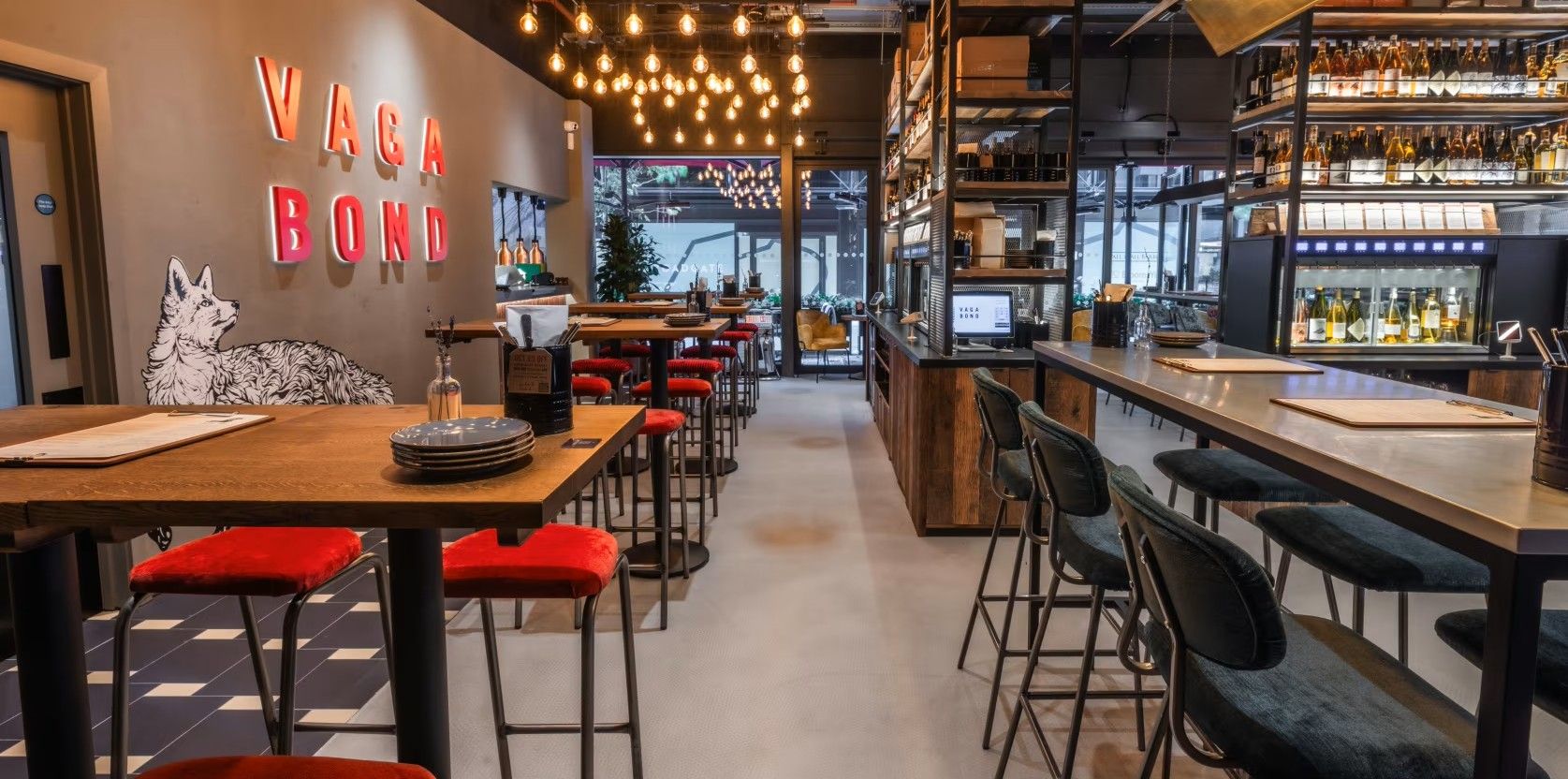 Vagabond Broadgate10 Captured inside a restaurant, the Caldas Coffee Table with a wooden top and metal base is presented amongst counter seating and pendant lighting.
