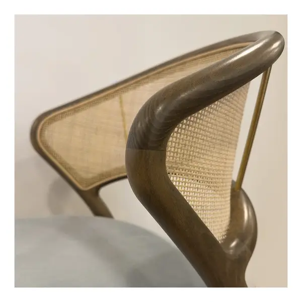 Close-up of the Nob Side Chair: wooden frame, upholstered seat, and woven back for a contemporary and comfortable design.