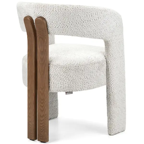 Angled view of the Berry Armchair featuring a textured white, upholstered seat and back with a wooden frame.