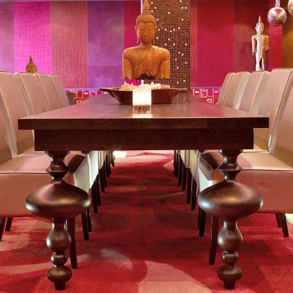 Eye-level view of the Marie Rectangle Dining Table, showcasing its dark wood finish, turned legs, and surrounding dining chairs in a vibrant setting.