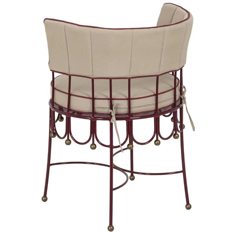 Back view of a Maroon Armchair with a grid-patterned metal frame, tie-on beige cushions, and delicate ball-tipped legs.