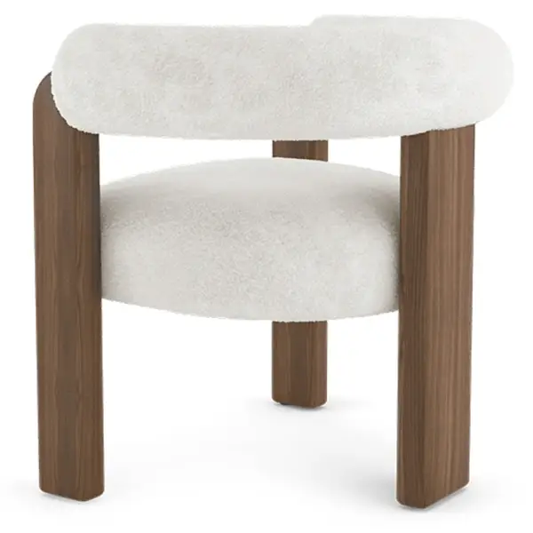 Profile angle of the Auro Armchair highlighting its thick, textured white upholstery and heavy walnut wood frame base.
