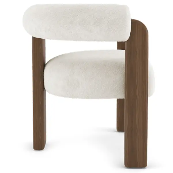 Rear-angle view of the Auro Armchair showing its sculptural, boucle-upholstered back and sturdy dark wood frame legs.