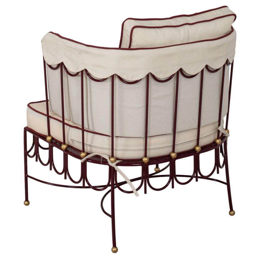 Back view of the Halycon Lounge Chair showcasing the scalloped maroon metal frame, golden hardware, and cream cushions.