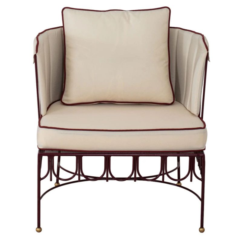 Front view of the Halycon Lounge Chair featuring a maroon ornate metal base and cream upholstered cushions with red trim.