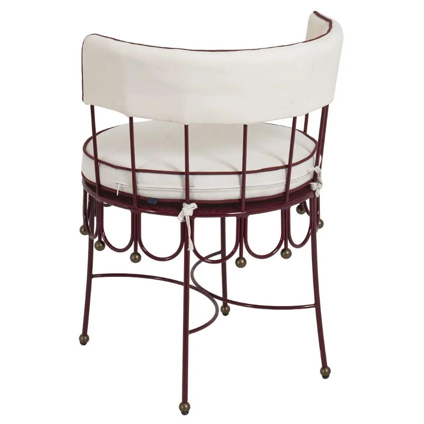 Rear perspective of a Maroon armchair showing the intricate metal lattice base, tie-on cream cushions, and ball feet.