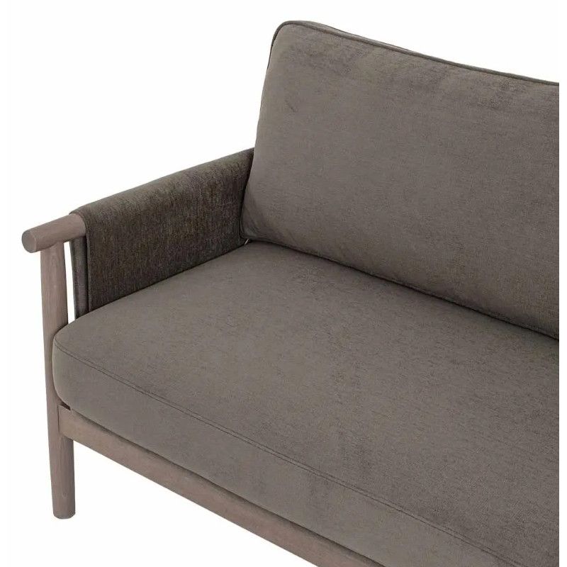 High-angle detail of the Merinal sofa showing grey fabric upholstery and the sculpted armrest on a wooden frame.
