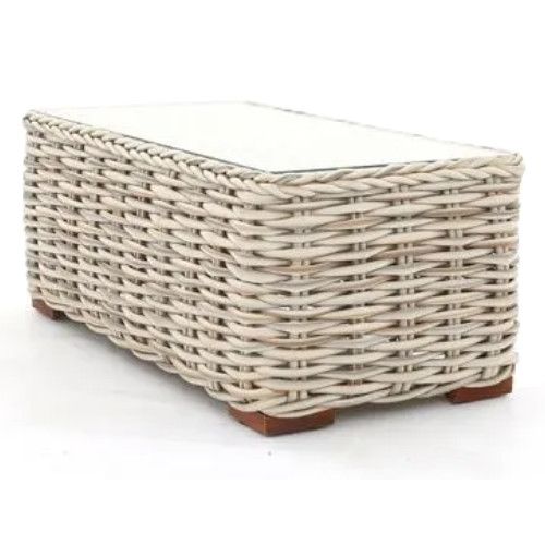 Tula coffee table featuring a light-toned wicker frame with a smooth glass top on durable brown wooden feet.