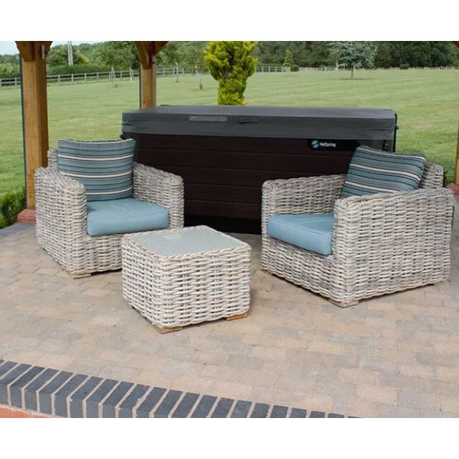 Tula Lounge Chairs featuring light wicker frames and blue striped cushions arranged with a matching low stool on patio.
