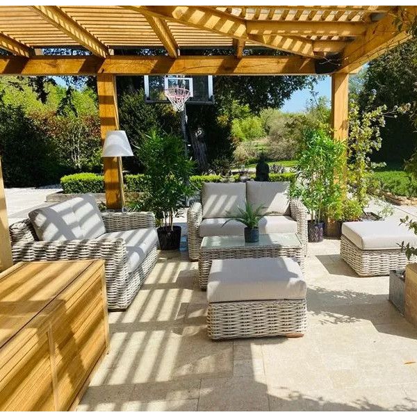 Tula sofa set with beige cushions and woven frames arranged under a wooden pergola on an outdoor stone terrace.