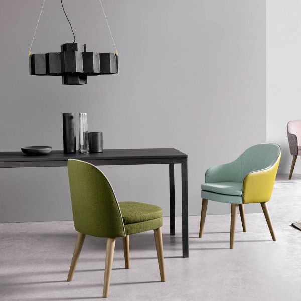 Two Carmen Side Chairs showing olive green and two-tone pastel upholstery, light wood legs, in a modern dining setting.