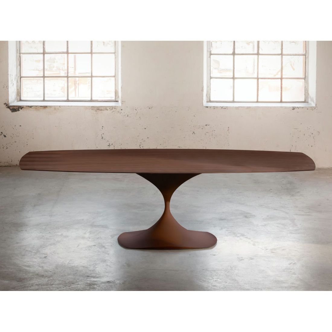 Front view of a Leo Dining Table featuring a wide wood-grain surface supported by a central sculptural metal base.