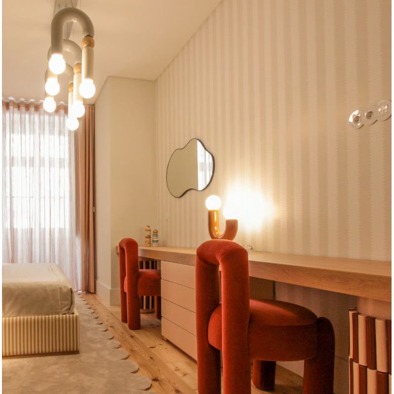Play III pendant light featuring U-shaped metal and oak accents, glowing in a modern bedroom interior from a side angle.