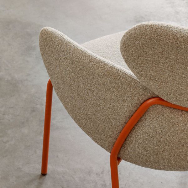 Close-up of the Vida armchair featuring a warm oatmeal textured seat and a vibrant orange powder-coated metal frame.