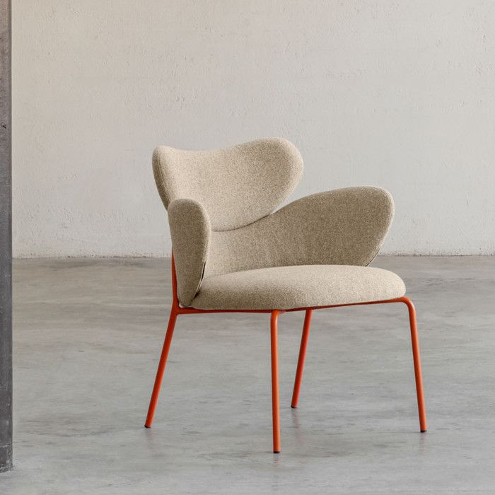 Vida armchair featuring curved beige seat upholstery supported by a minimalist orange metal frame on concrete floor.
