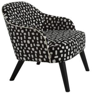 Carmen lounge chair with black and white patterned upholstery, curved back, white piping, and dark tapered wooden legs.