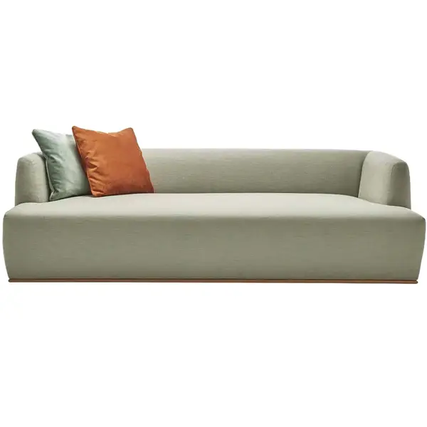 Estival sofa featuring sage green upholstery, a wooden base, and contrasting mint and burnt orange scatter cushions.