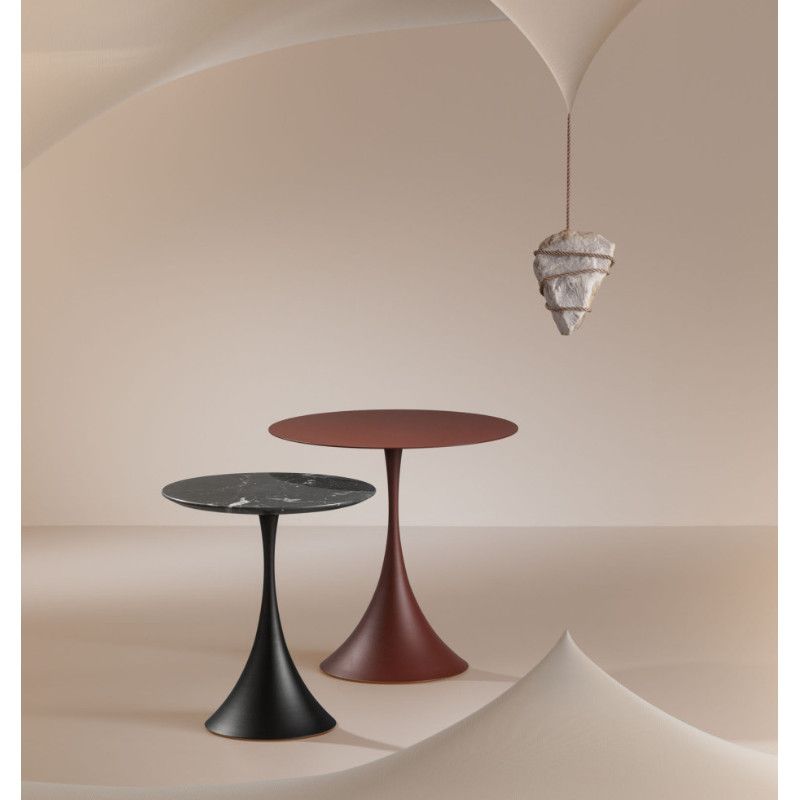 Two Leo coffee tables with pedestal bases, featuring one black marble top and one solid red top in a minimalist setting.