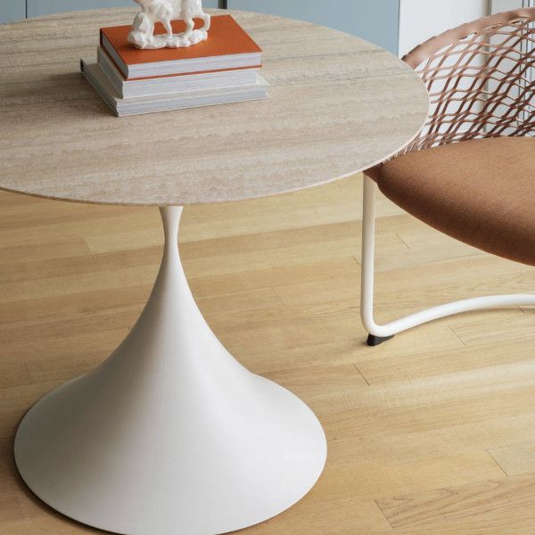 Close-up of the Leo Round Dining Table featuring a textured stone-look top and sculptural white pedestal base.