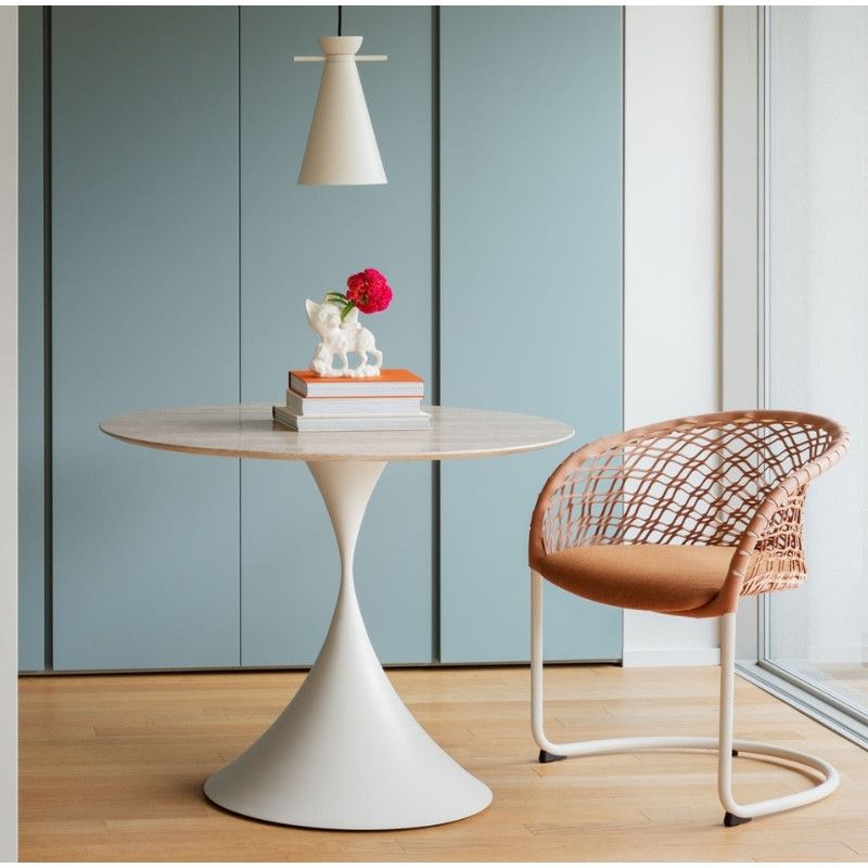 Leo Round Dining Table with a smooth white pedestal base and natural top, styled in a bright room with a woven chair.