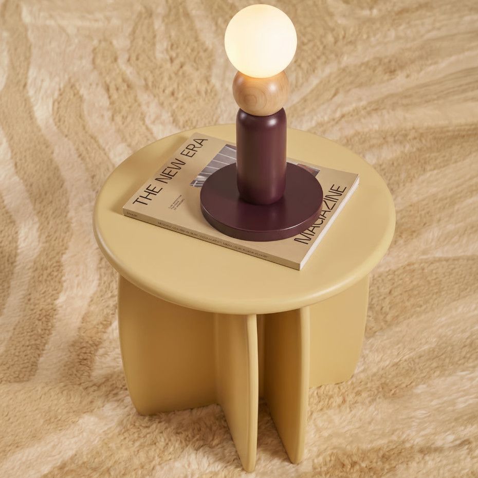 Play I Table Lamp featuring a deep plum base, smooth oak accent, and illuminated globe sitting on a mustard side table.