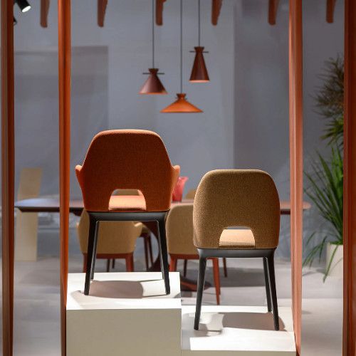 Rear view of two Relay Open Back Side Chairs featuring textured upholstery and dark wooden frames on display stands.