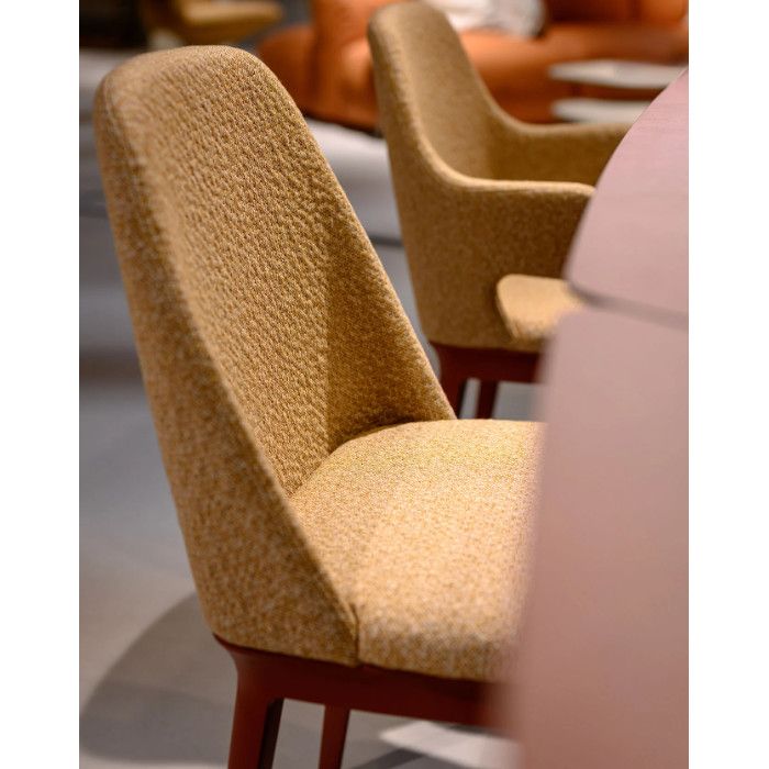 Close-up side view of a Relay Side Chair featuring golden-flecked upholstery and a dark wooden frame in a lounge setting.