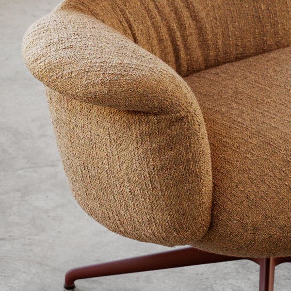 Detail shot of the Relay open back armchair upholstered in a tactile, coarse-weave fabric with a dark pedestal base.