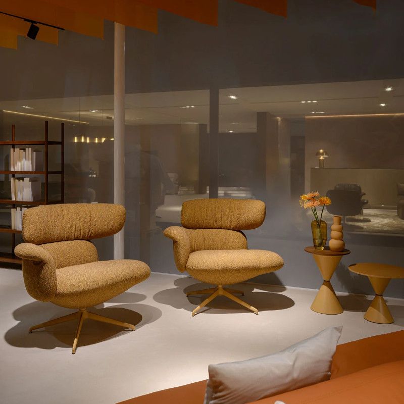 Two mustard-textured Relay open back armchairs with metal pedestal bases arranged in a contemporary interior setting.