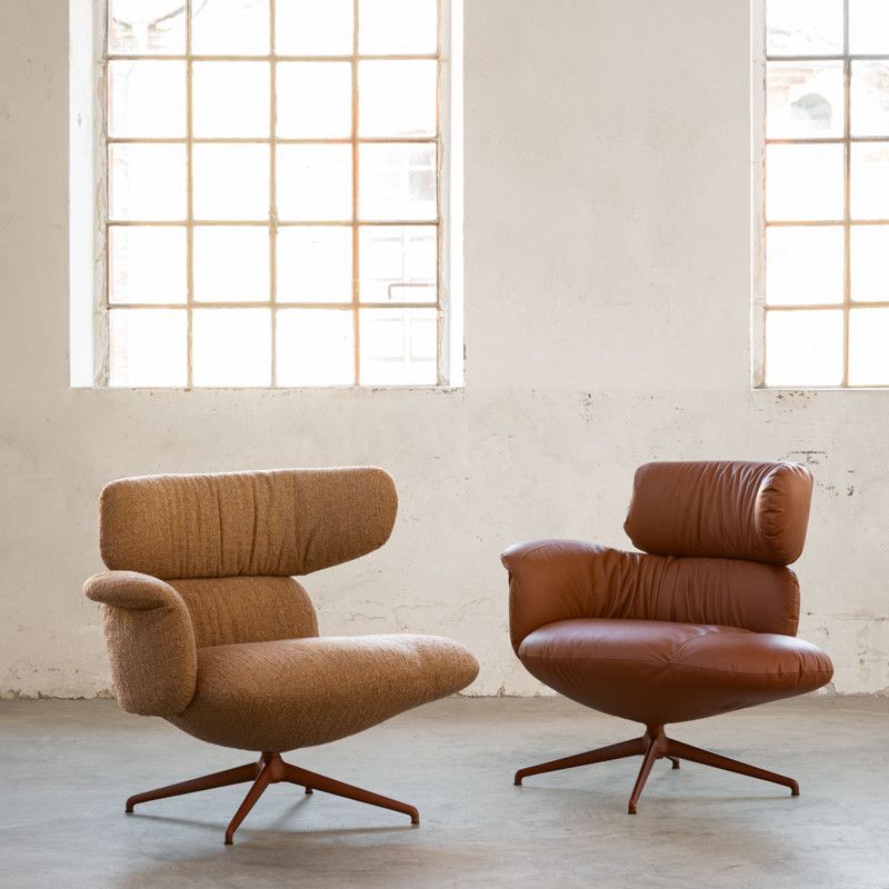 A pair of Relay open back armchairs featuring one in textured woven fabric and one in smooth leather with metal bases.