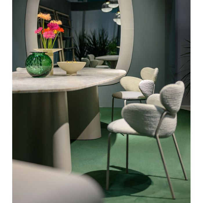 Vida armchairs with textured grey upholstery and slender metal legs in a contemporary dining arrangement.