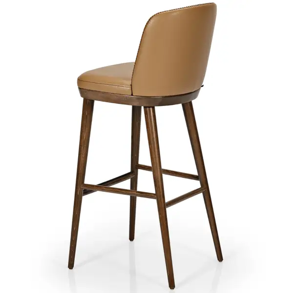 Amara lounge chair in tan upholstery with dark wood legs, viewed from a rear three-quarter angle.