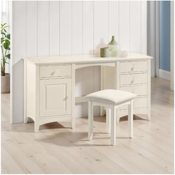 Cameo dressing table in cream finish with matching cushioned stool, shown in a bright room with light wood floors.