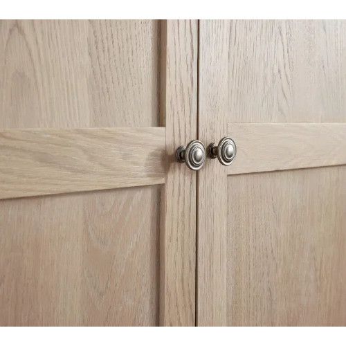 Detail shot of the Cameo wardrobe highlighting natural wood grain panels and brushed metal round door knobs.