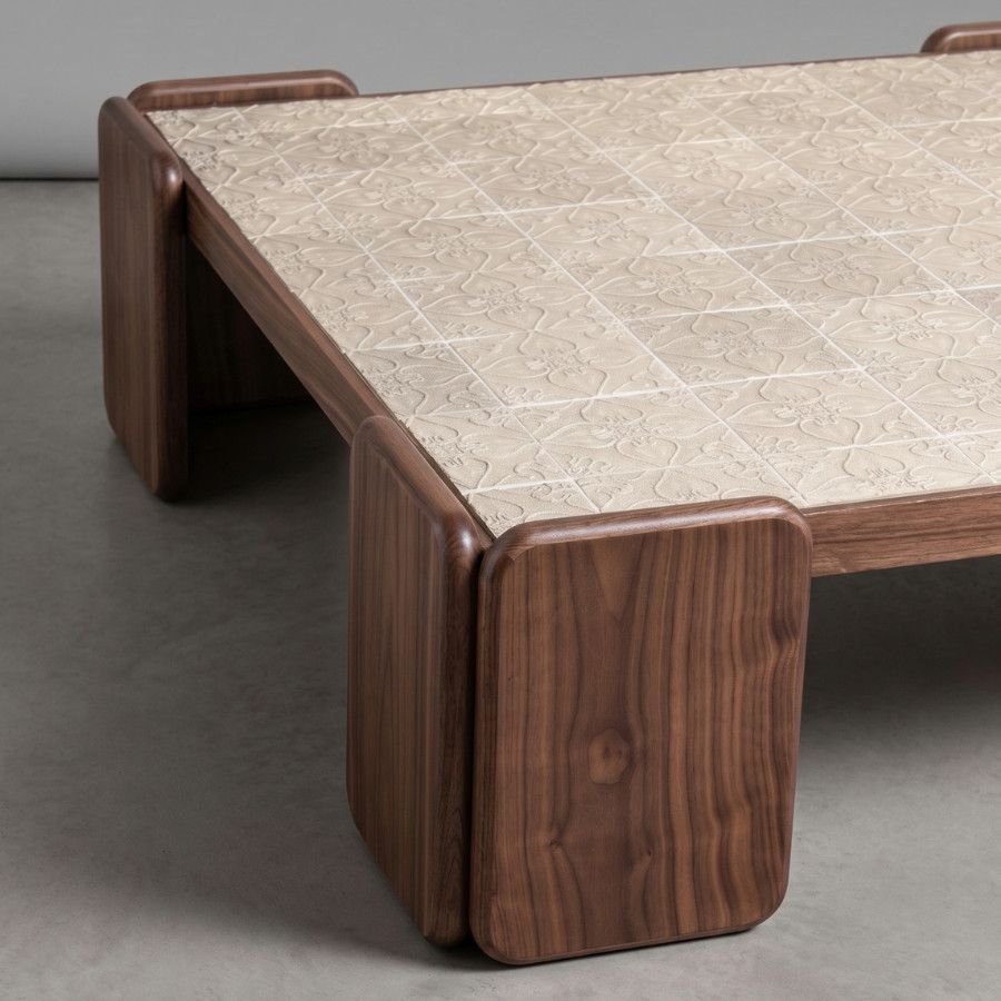 Low-angle side detail of the Chess Coffee Table showcasing its rich walnut frame and textured cream porcelain tile inlay.