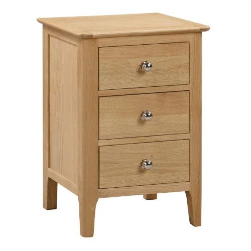 Cotswold bedside table in natural wood finish with three drawers and polished silver round knobs, studio shot.