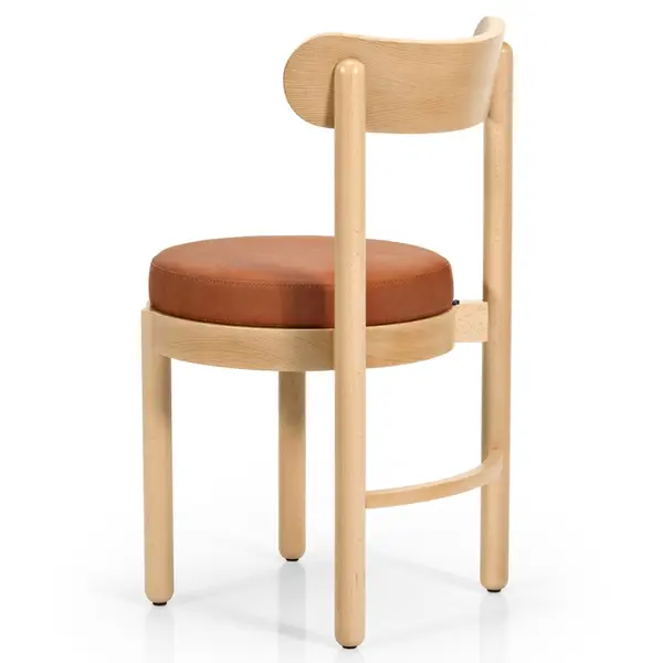 Rear view of the Doris Side Chair, showcasing its curved wooden backrest, light timber frame, and tan upholstered seat.