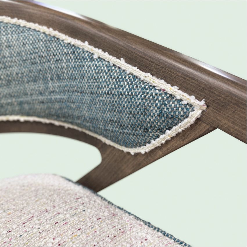 Close-up of Florence lounge chair showing wood frame, blue textured backrest, and cream upholstered seat pad.