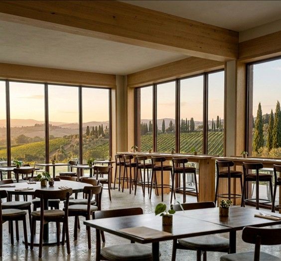 Fondina W Side Chairs in a bright, scenic restaurant overlooking a vineyard at sunset with natural wood decor.