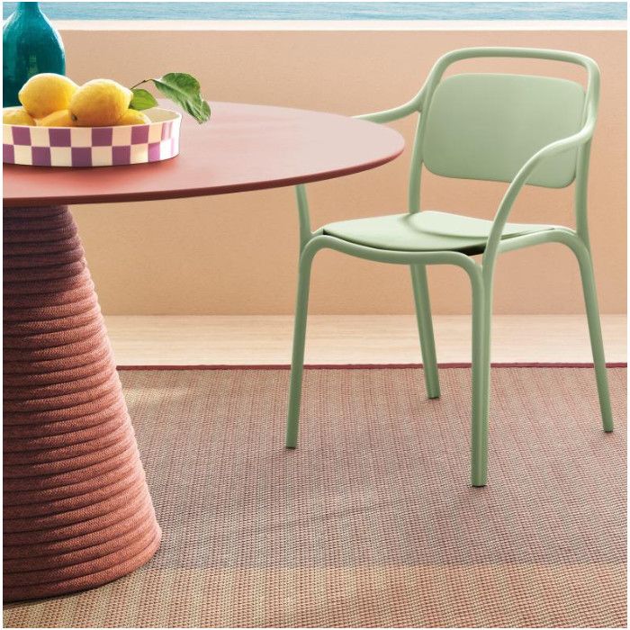 Ikon Twist dining table with a red top and rope pedestal, accompanied by a sage green chair on a patterned rug.