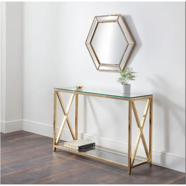 Miami Console Table with gold finish and glass surfaces positioned below a matching hexagonal wall mirror.