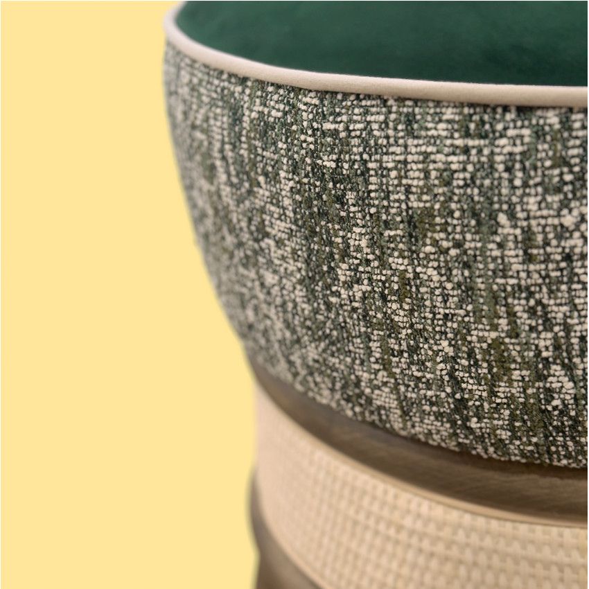 Close-up of Miko Low Stool showing deep green velvet, speckled tweed sides, and a cream-colored base against yellow.