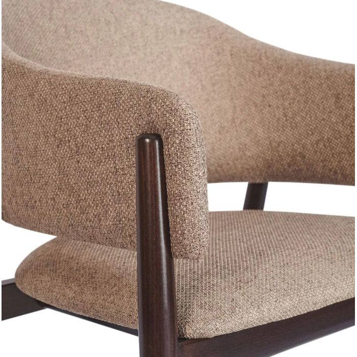 Close-up detail of the Milo Armchair showing the junction of the dark wooden arm and the textured taupe upholstery.