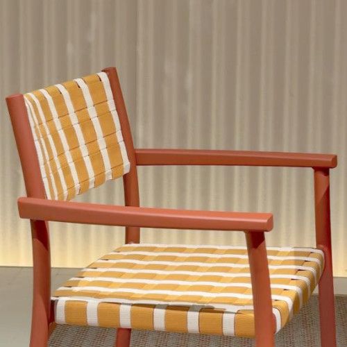 Nuova Guinea armchair in terracotta finish with a high-contrast yellow and white woven seat, angled view.