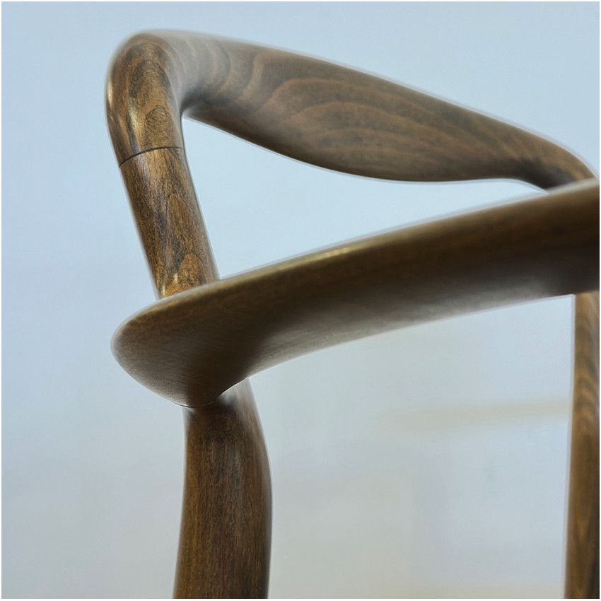 Close-up detail of the smooth, dark wood curved backrest and frame of a Verona Armchair against a plain background.