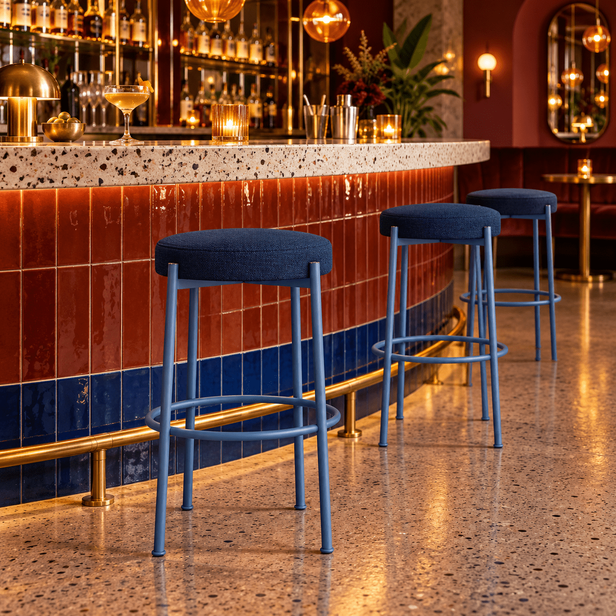 Group of Giotto high stools with blue metal frames and upholstered seats placed in a sophisticated bar interior.
