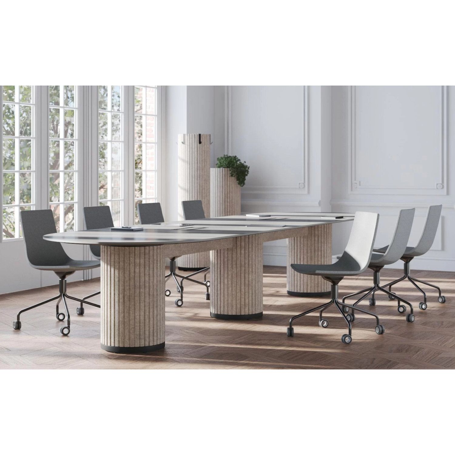 Extended Parthos meeting table with triple fluted beige pedestals, paired with charcoal office chairs in a bright room.