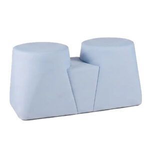 Ada Double Pouf in light blue upholstery with two cylindrical seats and connecting bridge, angled view.