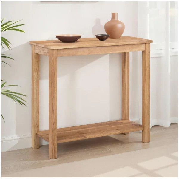 Coxmoor Console Table in solid wood with two-tier design, styled with a vase and bowl against a white wall.