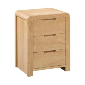 Curve Bedside table in natural oak finish with three drawers and rounded edges, shown from a front-side angle.